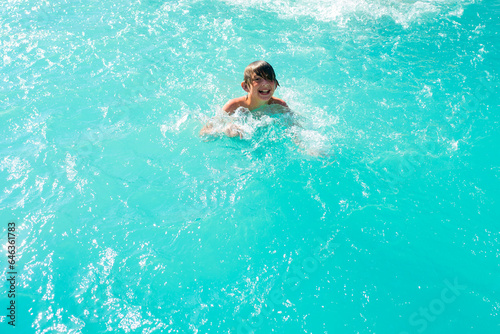 happy boy swim in the pool. joyful wet child swims in the water.  © Ruslan Russland