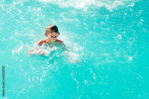 happy boy swim in the pool. joyful wet child swims in the water. © Ruslan Russland