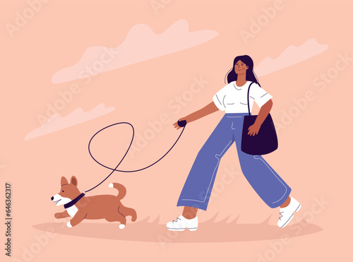 Young pretty woman walking with a dog, corgi owner teaching her exercises.