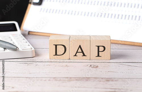 DAP word on a wooden block with clipboard and calcuator photo