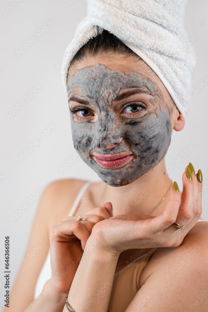 pretty sexy woman applying clay black mask on white background