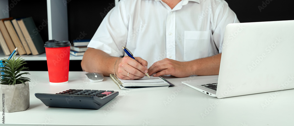 businessman using laptop, writing notes in diary. Office work or freelance businessman using laptop, writing notes in diary. Office work or freelance