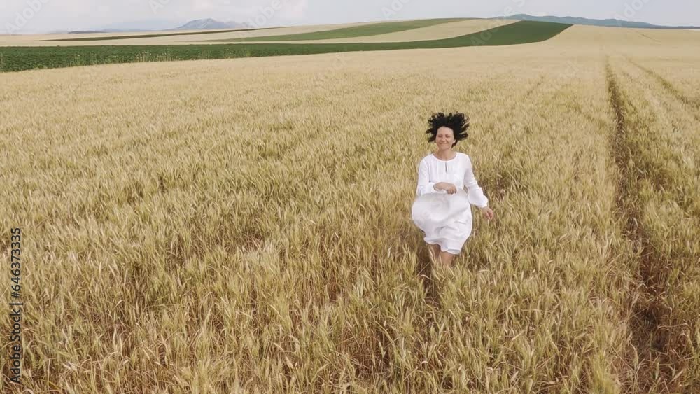 Carefree smiling positive woman running in wheat field throwing the hat, slow motion Carefree smiling positive woman running in wheat field throwing the hat, slow motion