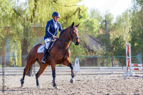 Young horseback sportsman on his course in showjumping competition © skumer