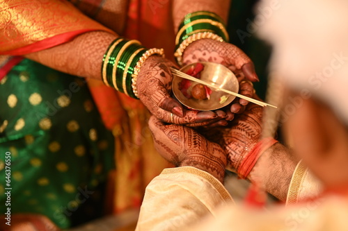 Hands of Indian Bride holding rose petals bowl. Indian groom holding hands of the bride and bowl. Glass Bangles. Kanyadaan ceremony. Marathi Wedding Rituals and Ceremony. Maharashtra. 