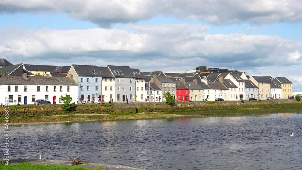 Pretty little houses of different colours along a river edge with birds flying, Galway Pretty little houses of different colours along a river edge with birds flying, Galway