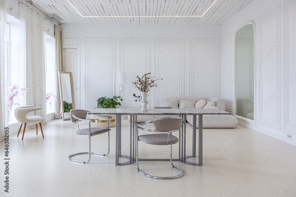 Fototapeta premium interior of a bright living room in a luxurious baroque style with white walls decorated with antique stucco