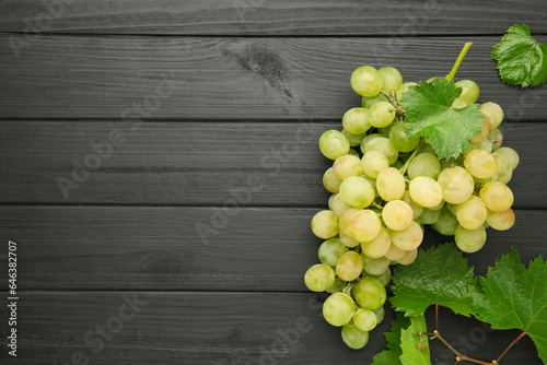Shine Muscat Grape. Bunch of green grape with leaves on black wooden background.