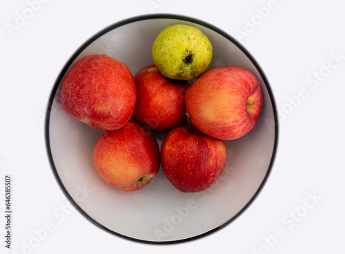 Red apples in white ceramic plate  macro shot  isolated on white background.