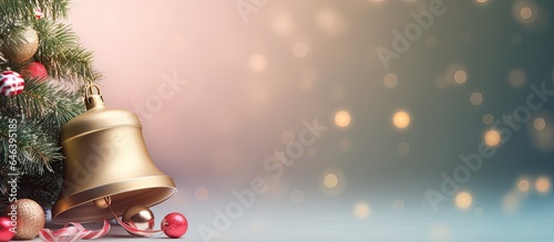Colorful bell shaped Christmas decorations hanging from the branches of a Christmas tree isolated pastel background Copy space
