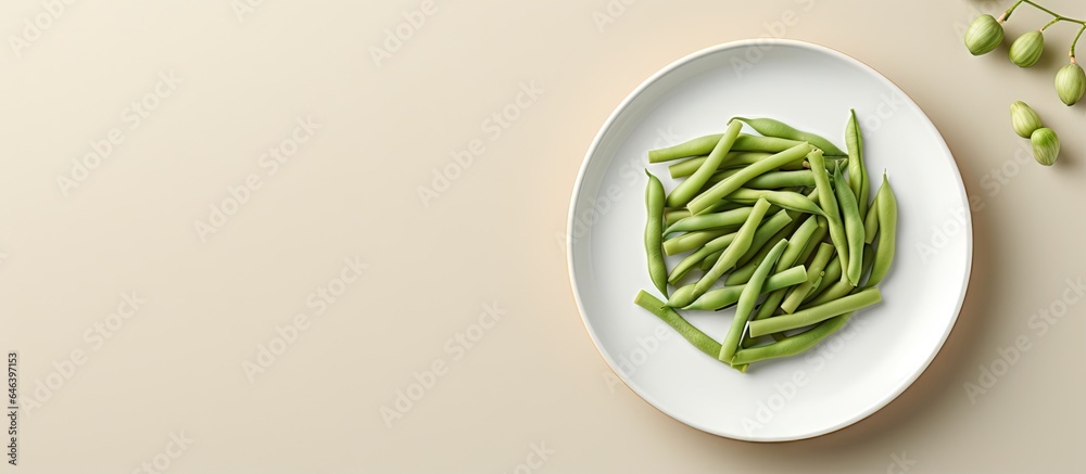 Obraz premium A closeup of green beans on a white plate on isolated pastel background Copy space