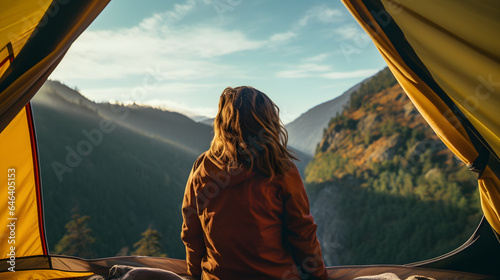 Serenity in the Wild: Young Woman Gazing at Mountain Vista from Tent
