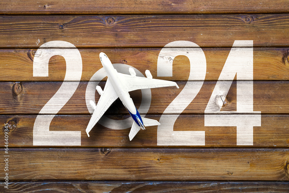 happy new year 2024. year 2024 with toy airplane on vooden desk Stock
