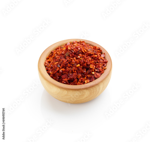 Crushed red pepper in wooden bowl isolated on white background