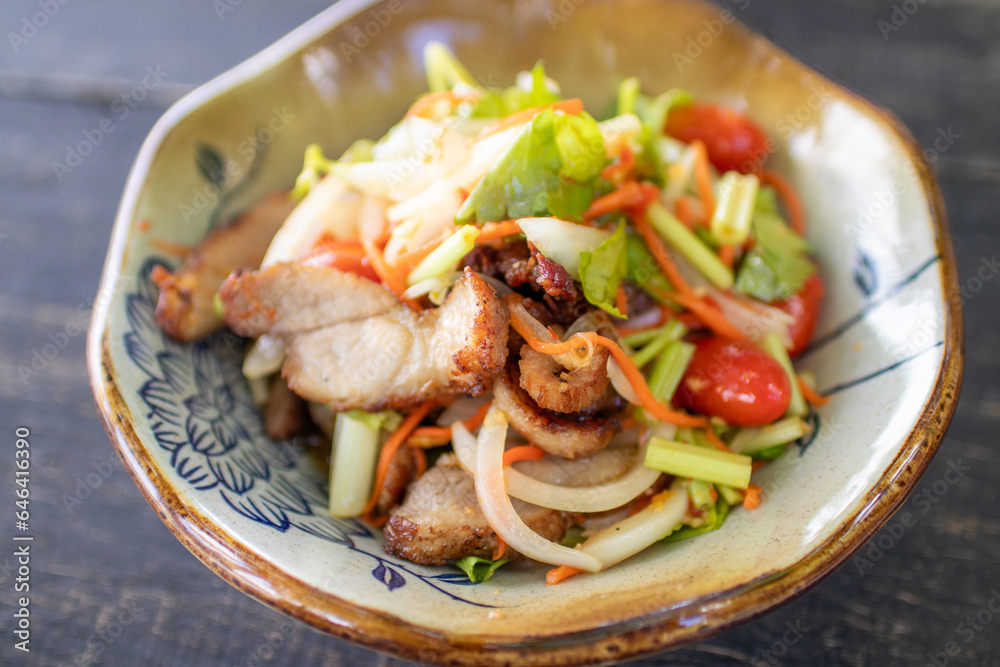 Grilled pork neck spicy salad with fresh herbs and vegetables.