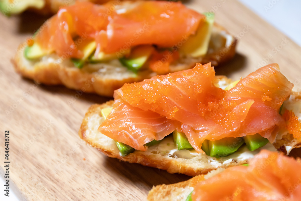 Smoked salmon with cream cheese and avocado slide on fresh croissants. Smoked salmon with cream cheese and avocado slide on fresh croissants.