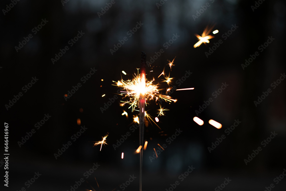Obraz premium photography, sparkler close-up on a dark background, holiday lights