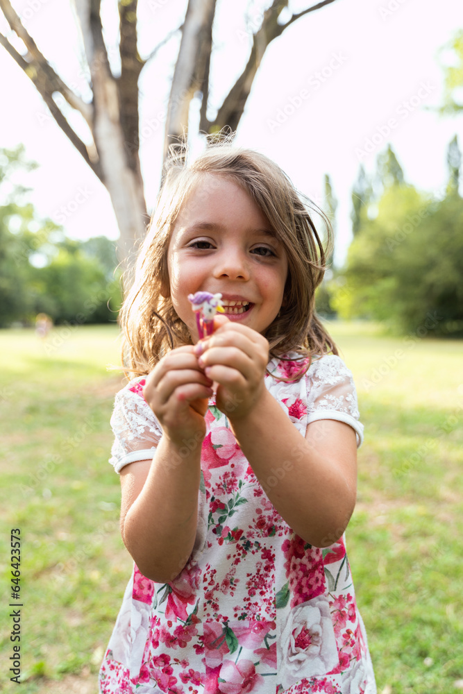 portrait of cute girl is showing a hair clip in a public park portrait of cute girl is showing a hair clip in a public park