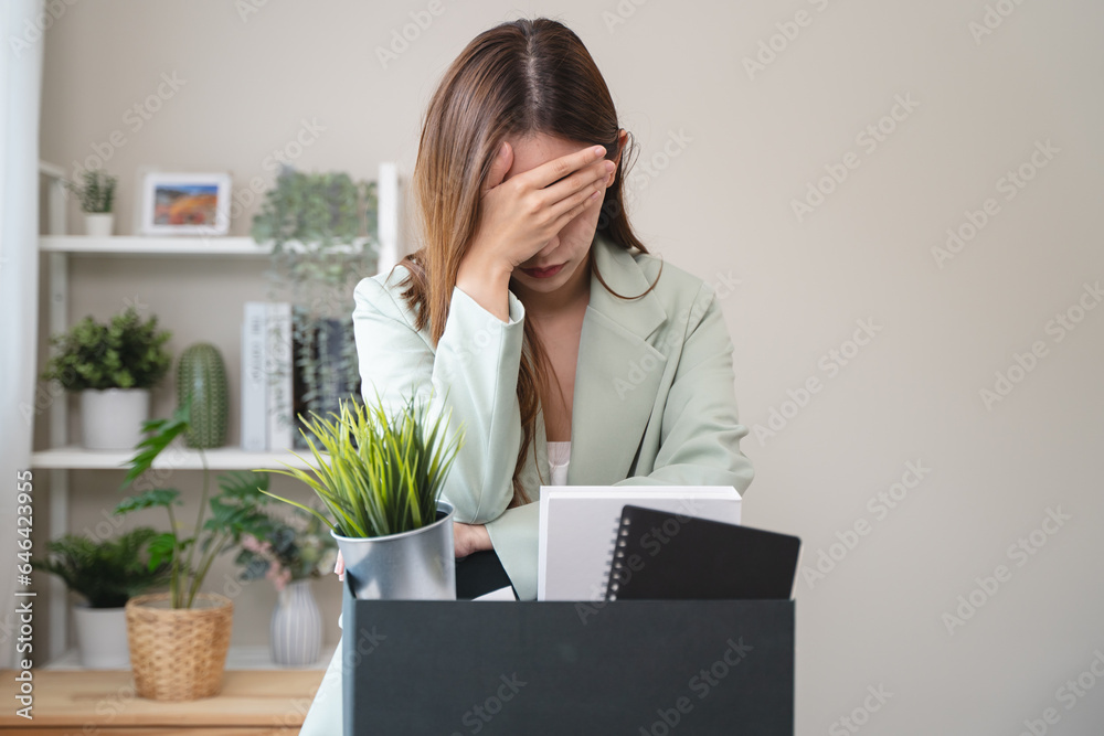 young employee packing her stuff on the desk in office to leaving work. person resigned from company to change job for promoted. young employee packing her stuff on the desk in office to leaving work. person resigned from company to change job for promoted.