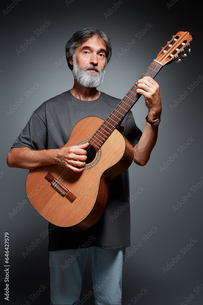 Fototapeta premium Aged bearded man with an acoustic guitar