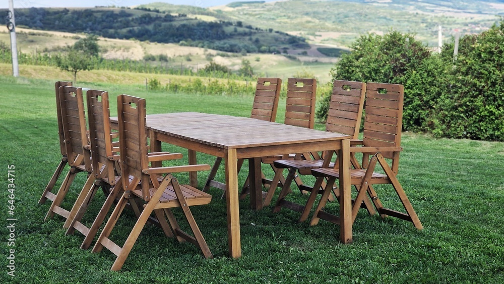 Wooden table and chairs, on green meadow, in summer day. Wooden table and chairs, on green meadow, in summer day.