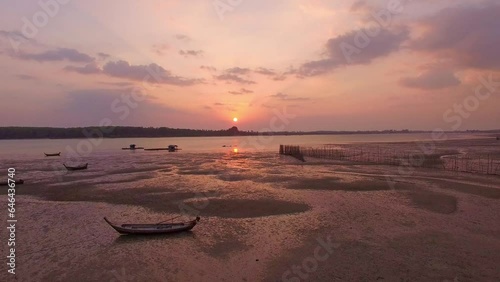 .Koh Raet is in Phang Nga Province, separated by the sea from Phuket Island..The pink sky reflects the water in the sea..Big sun and red lighting sky background. 4k resolution.Gradient color. photo