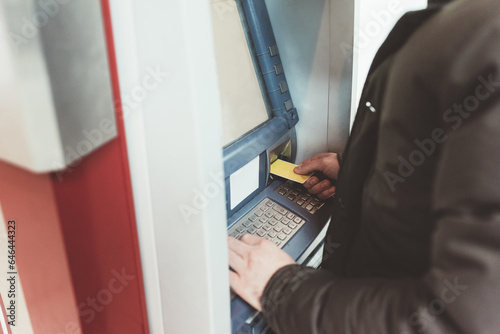 Close up unrecognizable person withdrawinnfg money at atm