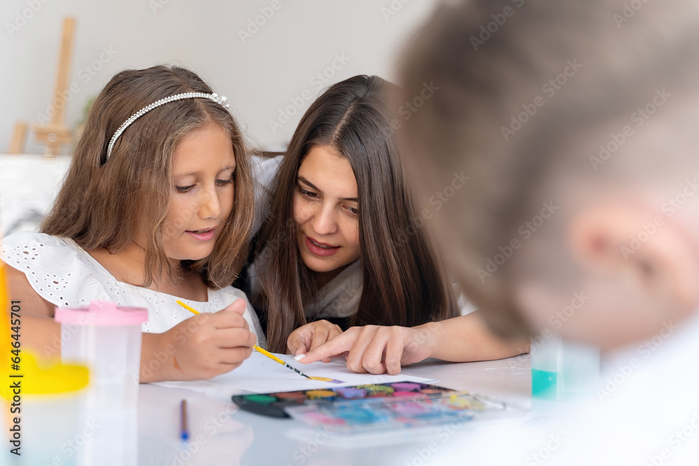 Teacher At Art School Helping Children in Art Class with painting. Teacher At Art School Helping Children in Art Class with painting.