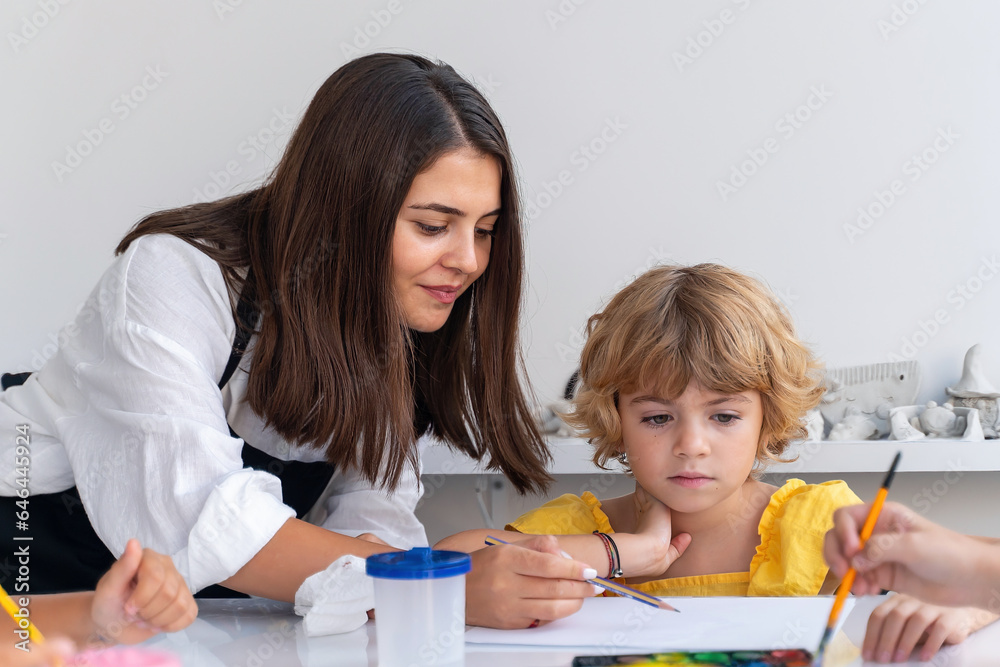 Teacher At Art School Helping Children in Art Class with painting. Teacher At Art School Helping Children in Art Class with painting.