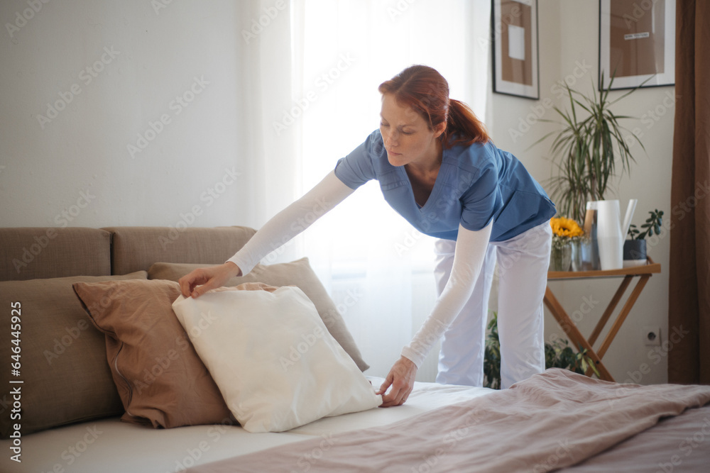 Nurse making the bed in the patient's room. Nurse making the bed in the patient's room.