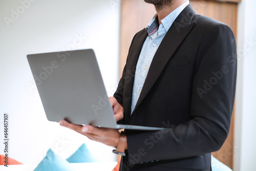 Caucasian businessman using laptop in modern office.