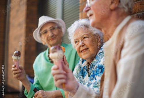 Portrait of three senior friends in the city, eating ice cream on a hot summer day.