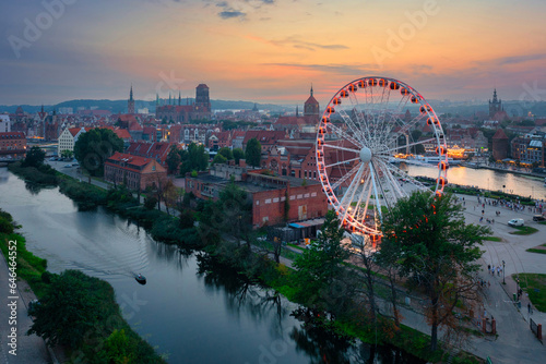Ferris wheel by the Main Town of Gdansk over the Motlawa river at sunset, Poland.
