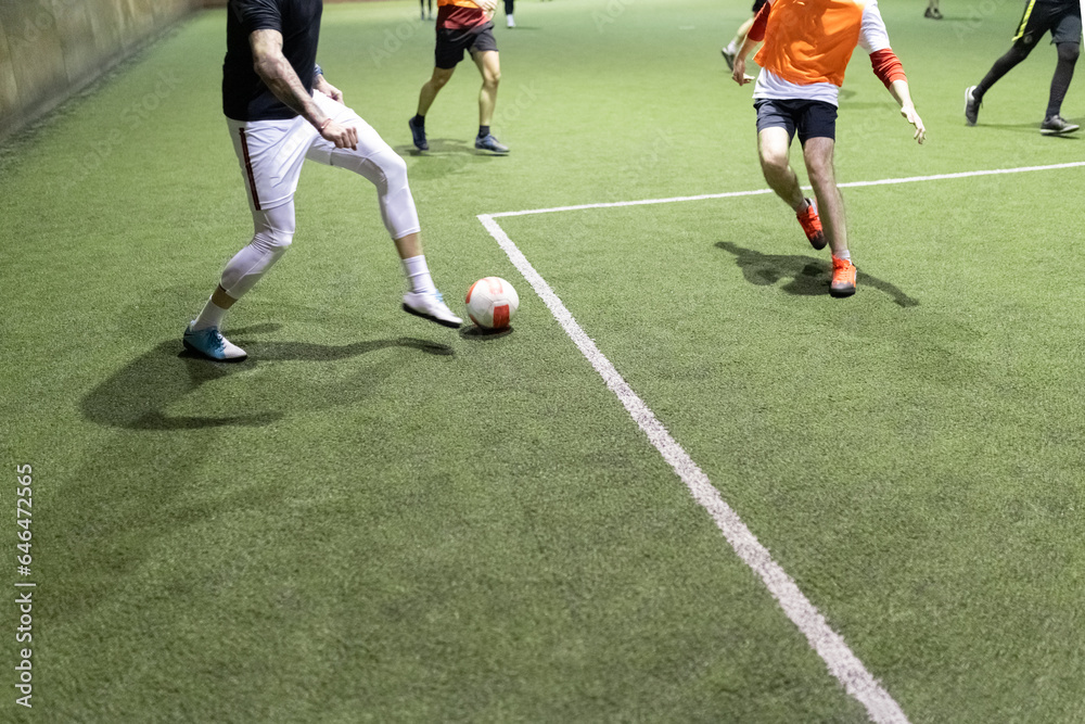 Futsal soccer football player in action on artificial grass court indoors. Futsal soccer football player in action on artificial grass court indoors.