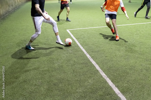Futsal soccer football player in action on artificial grass court indoors. © zphoto83