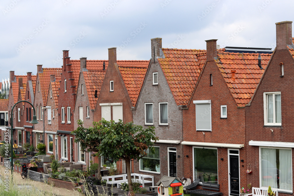 Fototapeta premium Classic Dutch houses on a street. Cute buildings with red tiles roof. Architecture of the Netherlands.