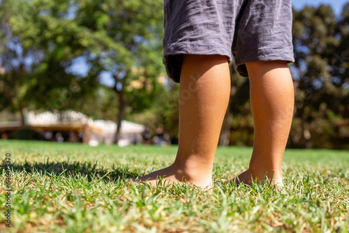 bare feet of a little boy close-up on green grass