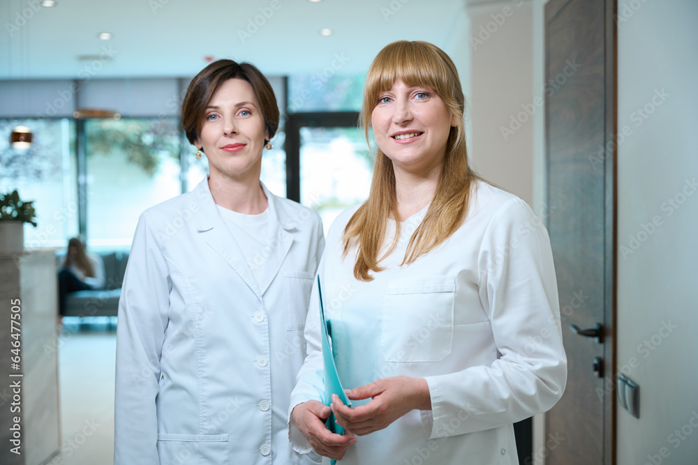 Fototapeta premium Women doctors stand in the hospital lobby at reception desk