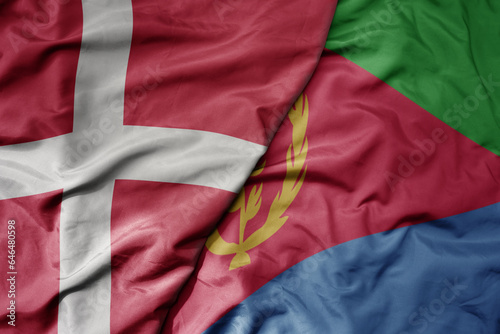 big waving national colorful flag of denmark and national flag of eritrea .