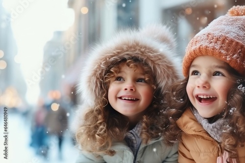 Two child girls smiling watching the snow fall