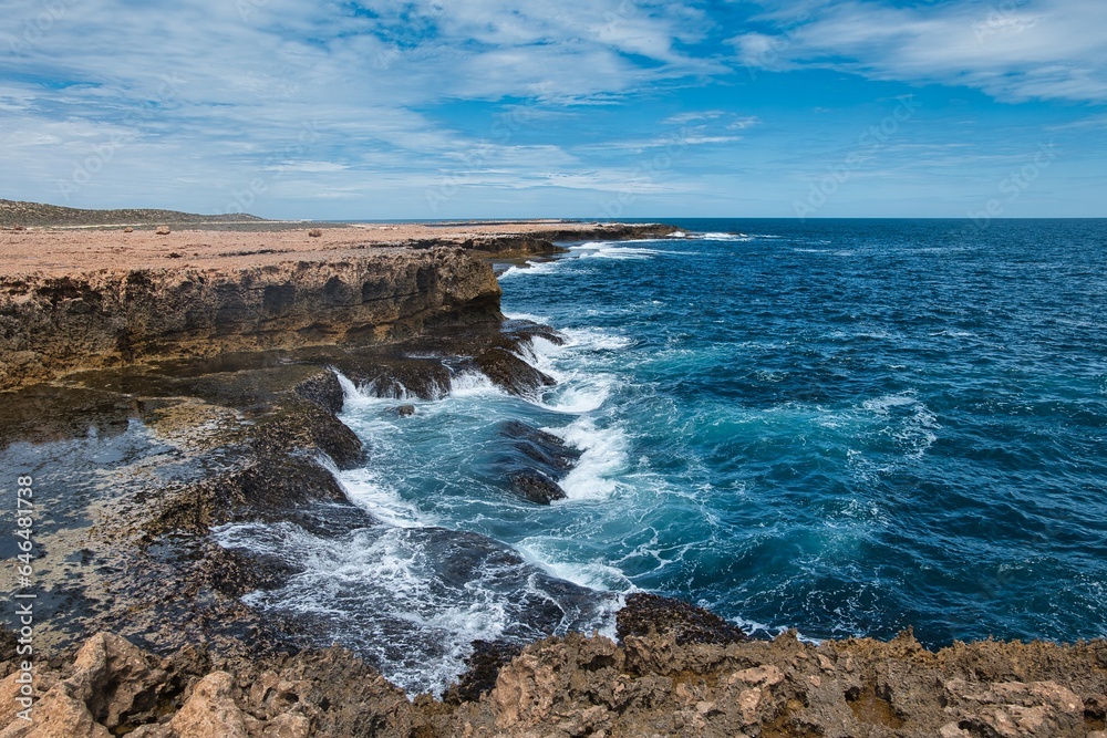 Coastline of Western Australia near Carnarvon. Point Quobba, Blowholes. Wild and rough coral coast. Powerful ocean swells force water through sea caves and up out of narrow holes in the rocks. 