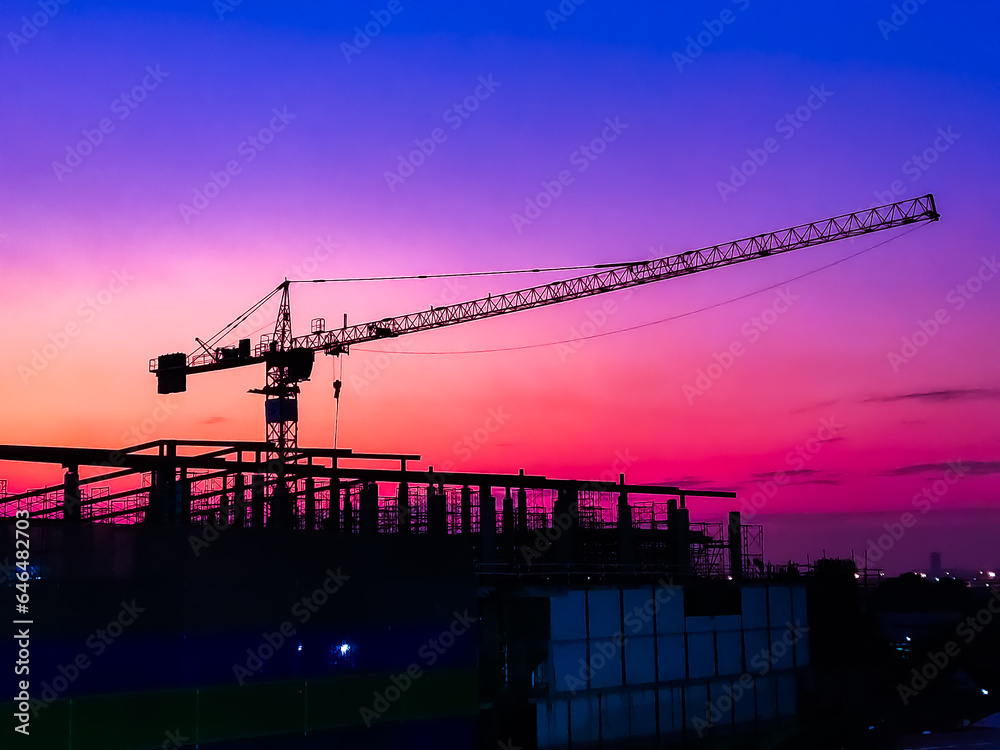 Large construction site including several cranes background Steel frame structure on a building sunset