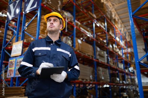 Portrait of confident male warehouse worker with digital tablet in warehouse. This is a paper package storage and distribution warehouse.