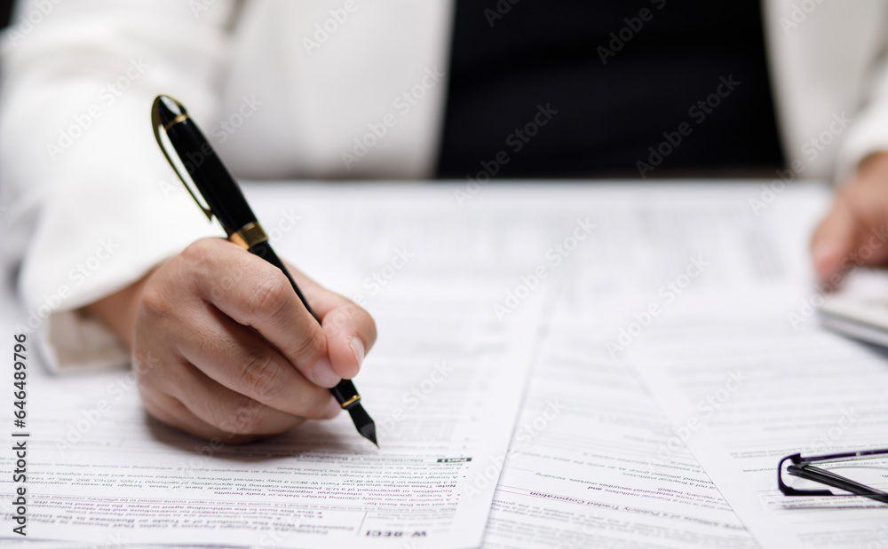 US IRS 1040 form or US Individual income tax Concept,accountant holding pen working on calculator business with data accounting documents and a laptop, pay tax in 2023 years,new year 2024 tax concept US IRS 1040 form or US Individual income tax Concept,accountant holding pen working on calculator business with data accounting documents and a laptop, pay tax in 2023 years,new year 2024 tax concept