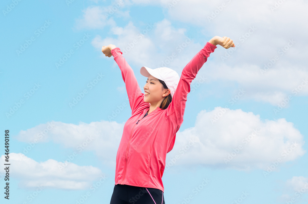 青空の下でストレッチをする若い女性 青空の下でストレッチをする若い女性