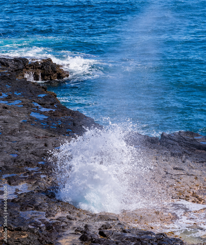 Vent of water from underneath lava rocks on coast of Kauai