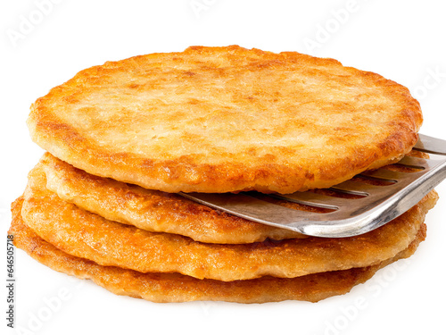 Stack of potato pancakes with spatula isolated on white.