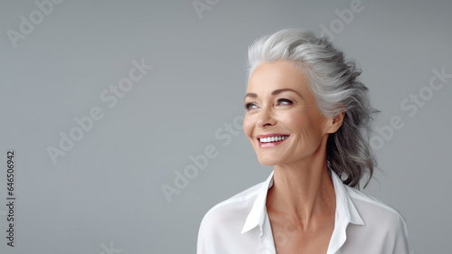 beautiful aging mature woman with gray hair and happy smiling, isolated on studio background