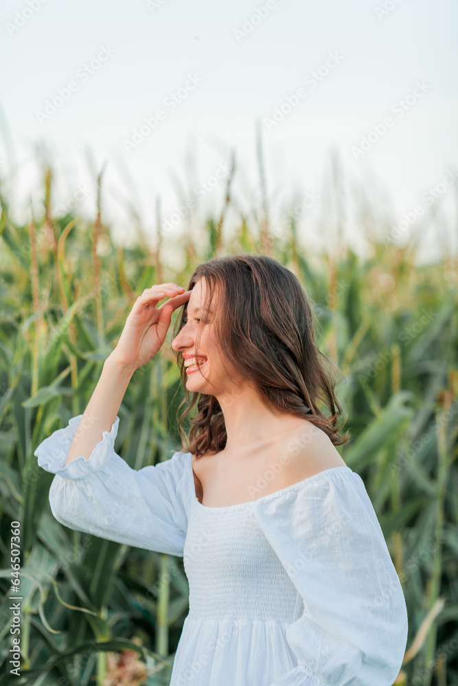 Young beautiful woman 26 years old in white simple dress in summer field. Green corn. Summer. Rustic style. Young beautiful woman 26 years old in white simple dress in summer field. Green corn. Summer. Rustic style.
