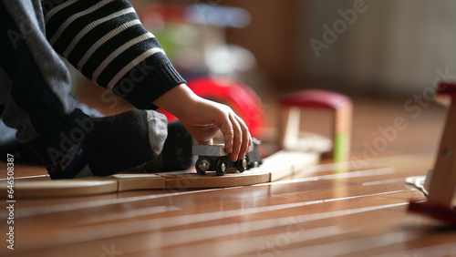 Child's hands playing with Antique Train Toy, Youngster Engaged with Railway Set Indoors, candid kid plays by himself at home